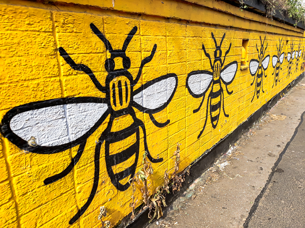 Manchester's emblem – the worker bee – painted on a yellow background on the wall of a former public toilet block, Stevenson Square, Northern Quarter, Manchester. © copyright Matthew Brace