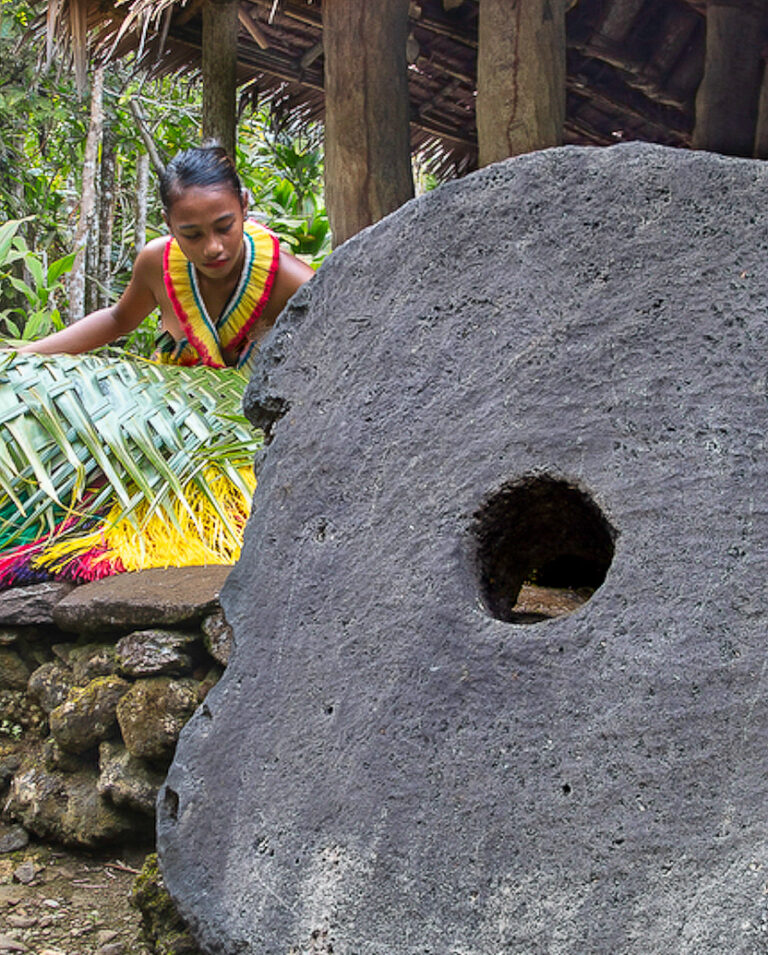Local girl and stone 'rai' money disc on the island of Yap in Micronesia. Photo courtesy of the Manta Ray Bay Resort © copyright David Fleetham