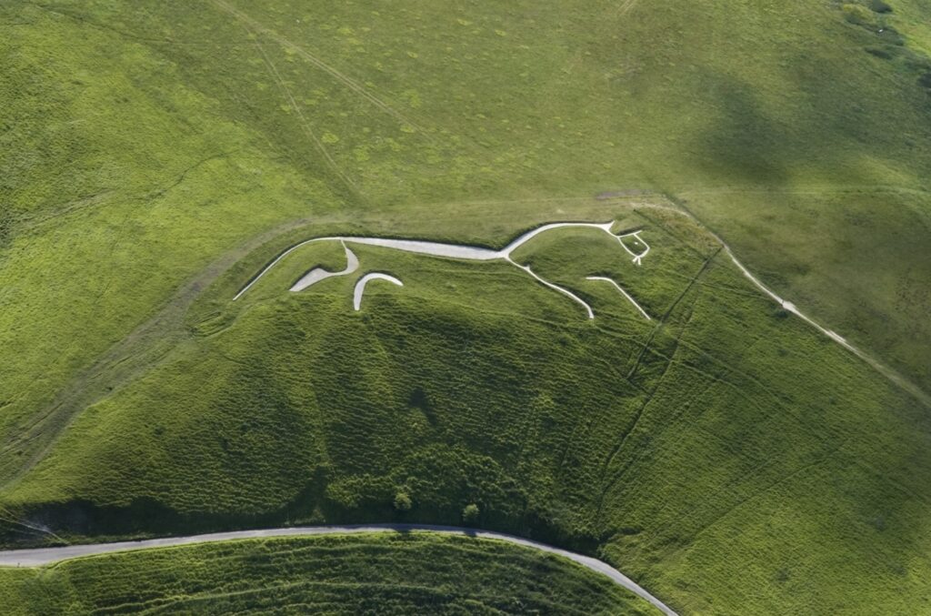 The White Horse of Uffington is a spectacular abstract chalk figure carved into an English hill roughly 3,000 years ago. © copyright Historic England Photo Library