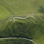 The White Horse of Uffington is a spectacular abstract chalk figure carved into an English hill roughly 3,000 years ago. © copyright Historic England Photo Library