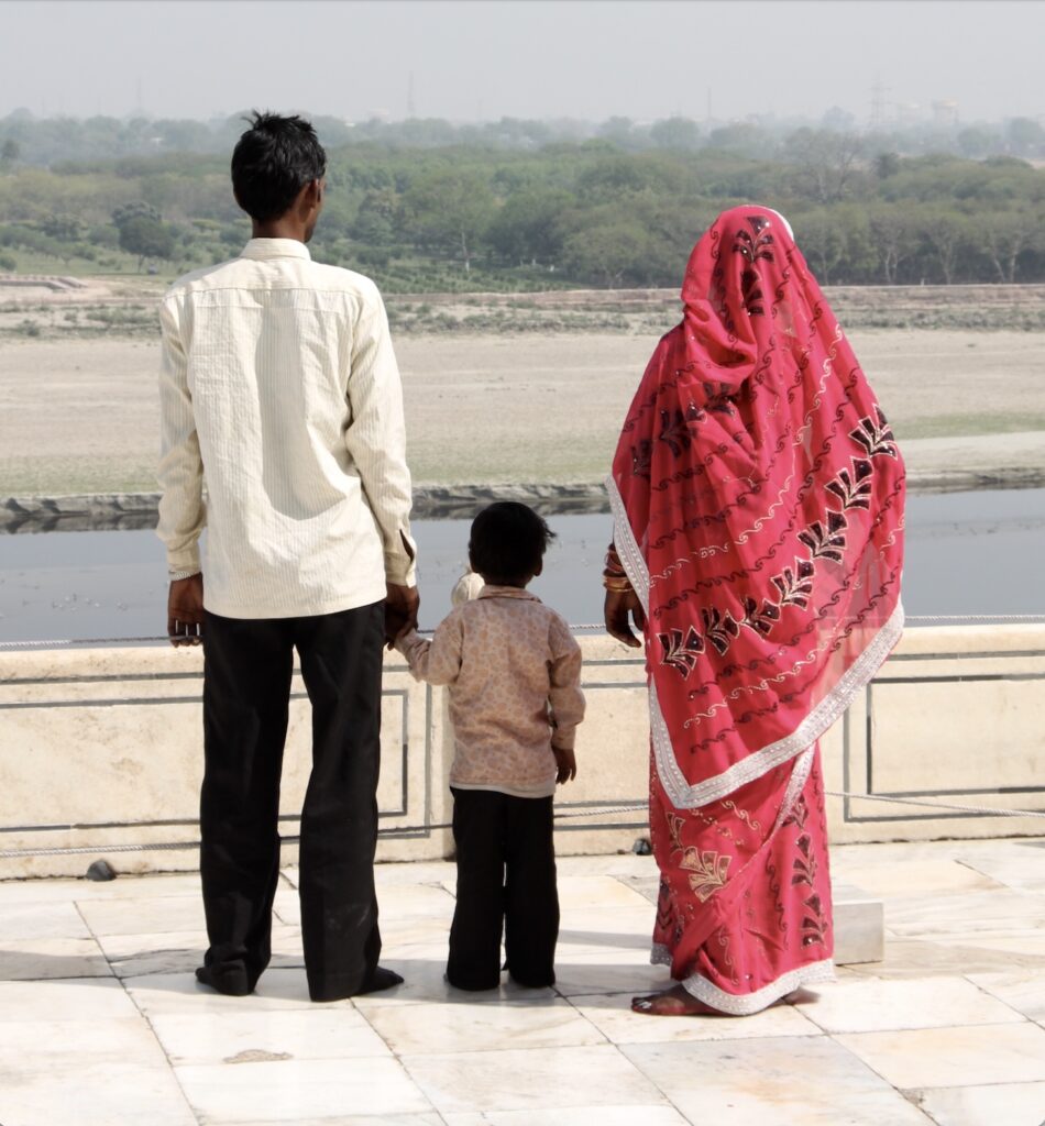 A family watches the sacred Yamuna River from the marble plinth surrounding the Taj Mahal, Agra, India. © copyright Matthew Brace